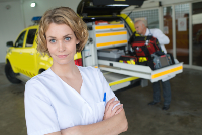 Nurse posing next to a medical car